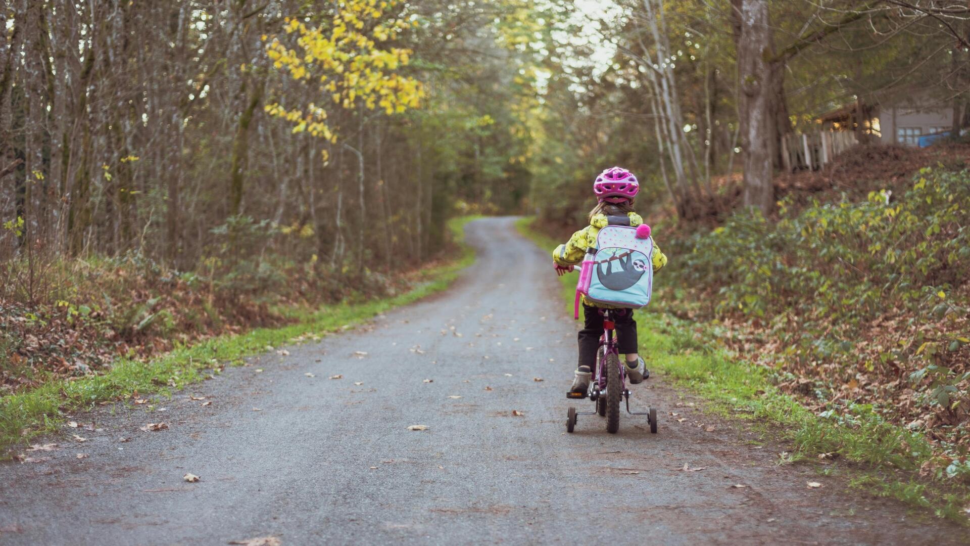 Kind op weg op kinderfietsje in het bos